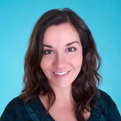 Sarah, a Chiropractic Assistant, smiling at the camera against a blue background